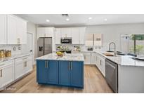 Bright kitchen features a blue island, white cabinetry, granite countertops, and stainless steel appliances at 2881 E Estrella Ct, Gilbert, AZ 85296