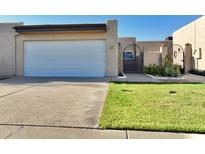 Charming single-level home features a two-car garage, manicured lawn, and gated front entry at 3345 E University Dr # 2, Mesa, AZ 85213
