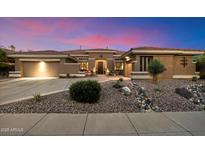 Charming home featuring desert landscaping, two car garage and stone accents enhancing the curb appeal at 42105 N Golf Crest Rd, Anthem, AZ 85086