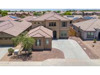 Two-story home featuring a well-manicured front yard and a tile roof at 45647 W Starlight Dr, Maricopa, AZ 85139