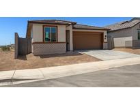 Charming single-story home featuring a two-car garage and a brick facade with desert landscaping at 5650 S 253Rd Ave, Buckeye, AZ 85326