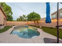 Backyard pool area featuring a lovely pool, a seating area, and well-maintained artificial turf at 7027 W Blackhawk Dr, Glendale, AZ 85308