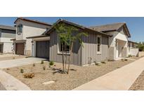 Charming home features low maintenance desert landscaping and a gray two-car garage at 9416 E Sequence Ave, Mesa, AZ 85212