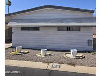 Charming single-story home with a grey trim, three white decorative flowerpots, and well-kept landscaping at 11411 N 91St Ave # 188, Peoria, AZ 85345