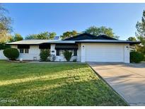 Charming single-story home featuring a well-manicured lawn and a two-car garage at 1742 W Butler Dr, Phoenix, AZ 85021