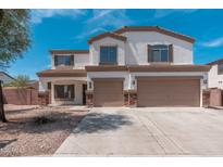 Two-story home featuring a two-car garage, white stucco, and brown trim at 22966 W Hopi St, Buckeye, AZ 85326