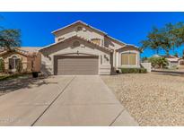 Charming two-story home featuring a tan stucco exterior, two-car garage, and low-maintenance desert landscaping at 640 W Country Estates Ave, Gilbert, AZ 85233