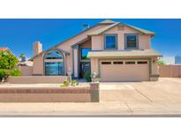 Charming two-story home with a well-manicured front yard, a two car garage, and desert landscaping at 7725 W Dreyfus Dr, Peoria, AZ 85381