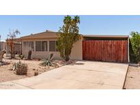 Charming home with desert landscaping and a wooden gated carport at 9347 E Edgewood Ave, Mesa, AZ 85208