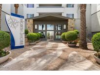 Inviting condo building entrance with desert landscaping, a covered entryway, and prominent signage at 945 E Playa Del Norte Dr # 1016, Tempe, AZ 85288