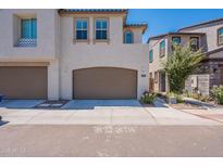 Inviting home exterior featuring a two-car garage, a well-manicured lawn, and stylish architectural details at 1055 W Diamondback Dr, Chandler, AZ 85286
