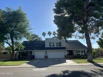 Charming two-story home featuring a well-manicured lawn and mature trees, complemented by a spacious driveway at 14622 N 45Th Pl, Phoenix, AZ 85032