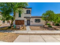 Inviting two-story home featuring low maintenance landscaping and a charming brick facade at 14885 W Ashland Ave, Goodyear, AZ 85395