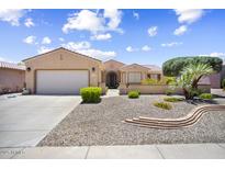 Charming home with a well-maintained desert rock front yard and a two-car garage at 17009 W Eureka Springs Dr, Surprise, AZ 85387