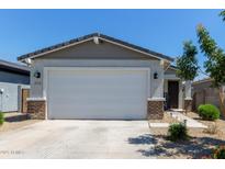 Exterior of home showing a two-car garage, desert landscaping, and a gray stucco exterior at 17338 W Via De Luna Dr, Surprise, AZ 85387