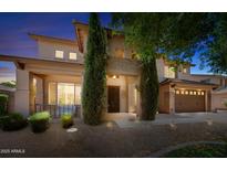 Inviting two-story home with meticulously landscaped front yard and charming architectural details at twilight at 2541 E Carob Dr, Gilbert, AZ 85298