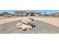 Charming single-story home showcasing rock accents, gravel landscaping, and a circular driveway at 28156 N Edwards Rd, San Tan Valley, AZ 85143