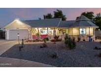 Charming single-story home with a well-maintained lawn, unique gazebo, and inviting front porch at twilight at 4013 E Delta Cir, Mesa, AZ 85206