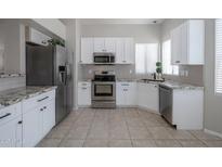 Bright kitchen features stainless steel appliances, white cabinets, and granite countertops at 839 W Silver Creek Rd, Gilbert, AZ 85233