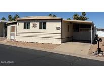 Tan home in a landscaped community with a covered parking area, desert landscaping and a low-maintenance yard at 9501 E Broadway Rd # 68, Mesa, AZ 85208