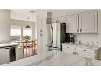 Bright kitchen with stainless steel appliances, white cabinets, and marbled countertops at 101 N 7Th St # 225, Phoenix, AZ 85034