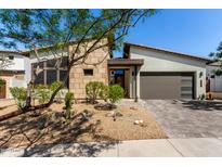 Modern home with stone accents, desert landscaping and a covered two-car garage at 1217 E Monte Way, Phoenix, AZ 85042