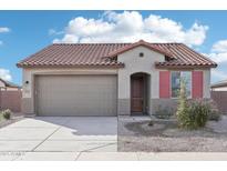 Charming single-story home with a tile roof, two-car garage, neutral stucco, and tasteful landscaping at 15611 W Hackamore Dr, Surprise, AZ 85387