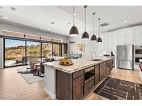 Stunning kitchen with a large island, stainless steel appliances, and an open floor plan leading to a cozy living room at 16134 E Ridgestone Dr, Fountain Hills, AZ 85268