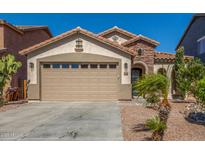 Charming single-story home with a two-car garage, stone accents, tile roof and desert landscaping in front at 33207 N Slate Creek Dr, San Tan Valley, AZ 85143