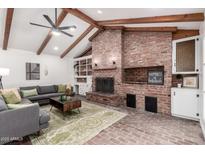 Bright living room featuring exposed wood beams, brick fireplace, and comfortable seating at 48 S Catalina St, Gilbert, AZ 85233