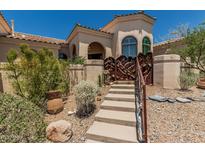 Inviting home entrance featuring well-maintained desert landscaping and a charming rustic gate at 6010 E Languid Ln, Carefree, AZ 85377