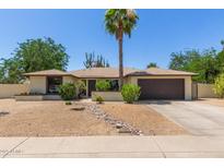 Charming single-story home featuring desert landscaping, a brick facade, and a two-car garage at 6417 E Kings Ave, Scottsdale, AZ 85254