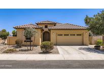 Charming single-story home featuring a tile roof, desert landscaping, and a two-car garage at 7665 W Fetlock Trl, Peoria, AZ 85383