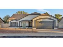 Charming single-story home featuring a two-car garage and desert landscaping in front at 7685 W San Miguel Ave, Glendale, AZ 85303