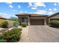 Charming single-story home with a well-manicured front yard and brick paved driveway at 8820 E Ivy Cir, Mesa, AZ 85207