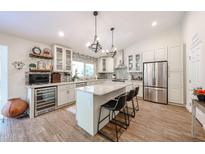 Bright, open kitchen with large island, stainless steel appliances, wine cooler and custom cabinetry at 9085 E Windrose Dr, Scottsdale, AZ 85260