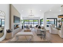 Bright, open living room with modern fireplace and seamless indoor-outdoor flow at 9450 N 83Rd Pl, Scottsdale, AZ 85258