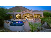 Inviting backyard featuring a pool with a water feature and spacious patio, set against a mountain backdrop at 11773 E Desert Trail Rd, Scottsdale, AZ 85259