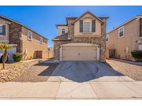 Two-story home featuring stone accents, a two-car garage and low-maintenance landscaping in a residential neighborhood at 18123 W Lundberg St, Surprise, AZ 85388