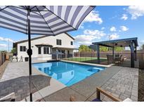 Beautiful backyard with a pool, patio umbrella, covered patio, and outdoor dining area at 19002 N 25Th Pl, Phoenix, AZ 85050