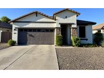 Charming one-story home featuring a gray garage door, stone accents, and low maintenance landscaping at 2715 E Canyon Creek Dr, Gilbert, AZ 85295