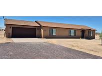 Single story home showcasing a two-car garage and a desert landscape at 31515 W Buchanan St, Buckeye, AZ 85326
