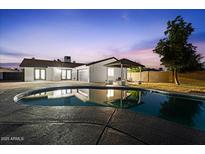Backyard pool with covered patio area and house reflection at dusk at 3506 W Yucca St, Phoenix, AZ 85029