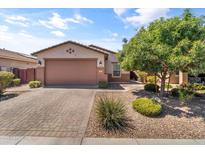 Charming single-story home featuring a brick driveway, desert landscaping, and a two-car garage at 455 W Evergreen Pear Ave, Queen Creek, AZ 85140