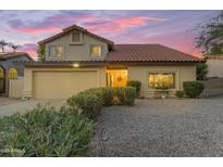 Charming home featuring a tile roof, two-car garage, and desert landscaping against a backdrop of pink and purple sunset at 5930 E Fountain St, Mesa, AZ 85205