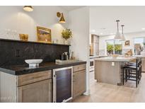 Stylish wet bar area with elegant countertop, bar refrigerator, and ample storage solutions, ideal for entertaining guests at 7432 E Holly St, Scottsdale, AZ 85257
