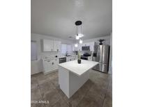 Modern kitchen featuring white cabinets, stainless steel appliances, and center island with pendant lighting at 13606 N 130Th Ave, El Mirage, AZ 85335