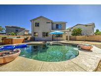 Stunning backyard pool with a hot tub and an umbrella in a low-maintenance backyard at 14719 N 176Th Ave, Surprise, AZ 85388