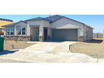 Charming single-story home with a stone facade, two-car garage, and a well-maintained desert landscape at 1540 E Mason Dr, Casa Grande, AZ 85122