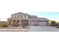 Charming two-story home features a three car garage and easy to maintain desert landscaping in front at 15656 W Desert Mirage Dr, Surprise, AZ 85379